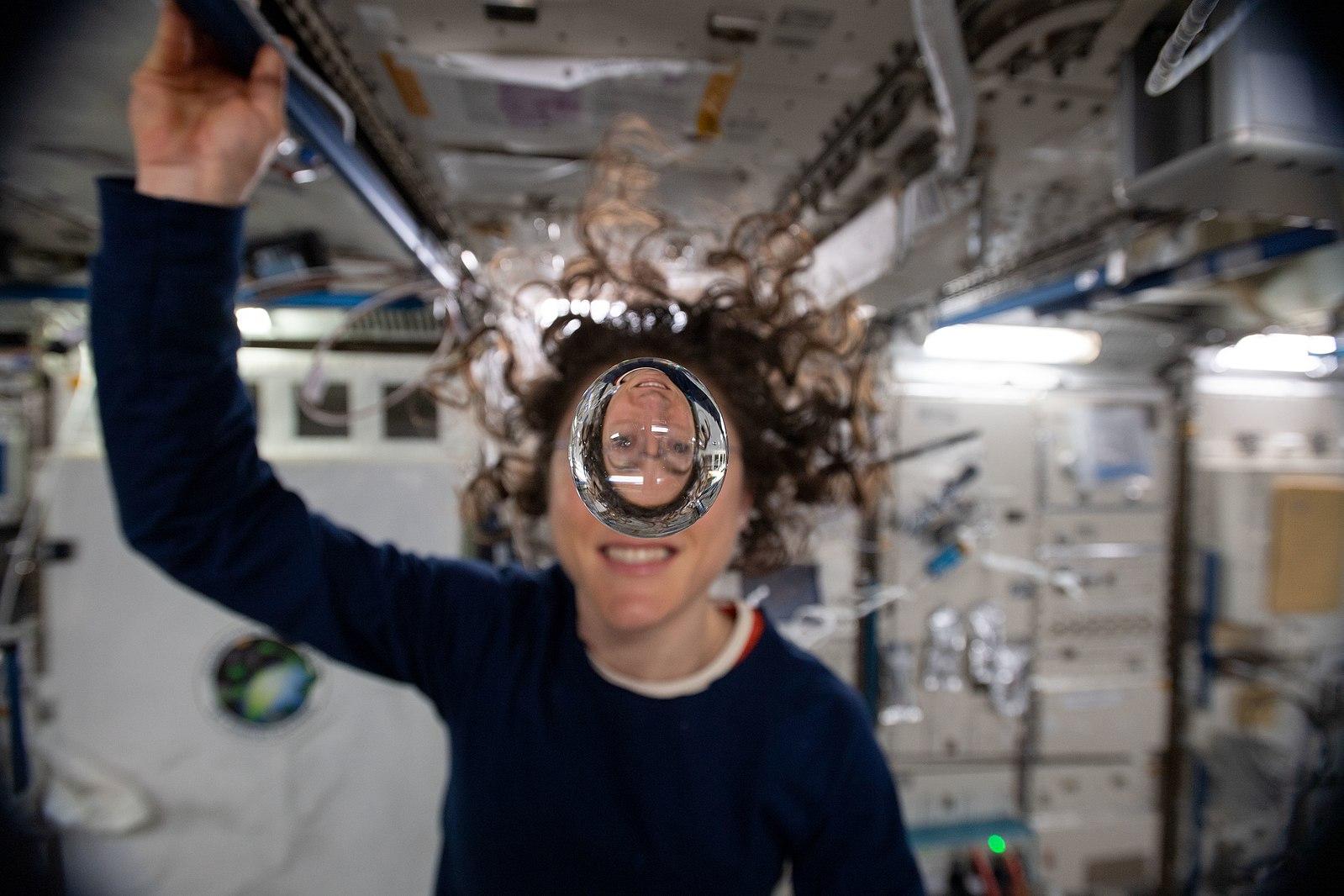 L'astronaute Christina Koch derrière une bulle d'eau flottante à bord de l'ISS