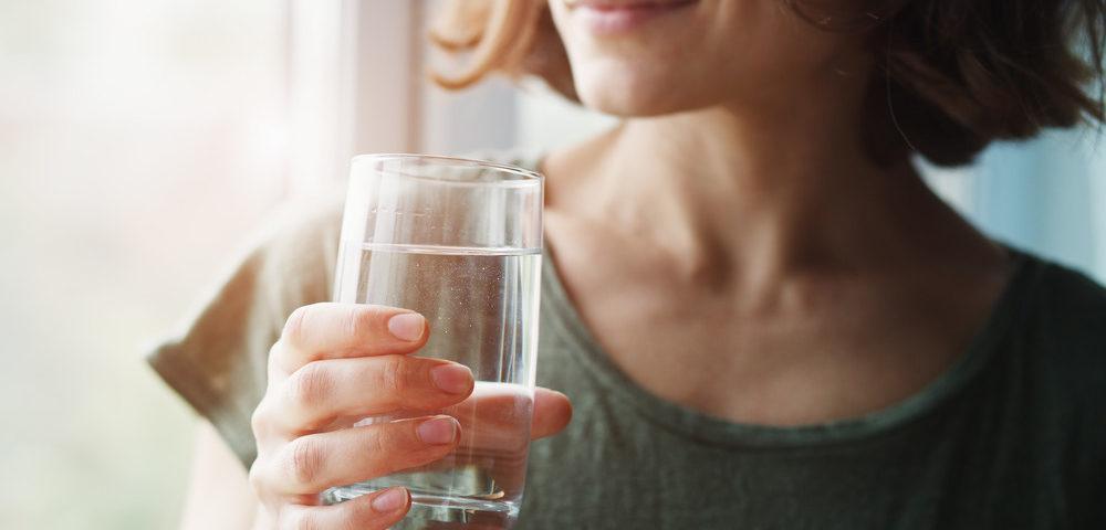 Femme tenant un verre d'eau