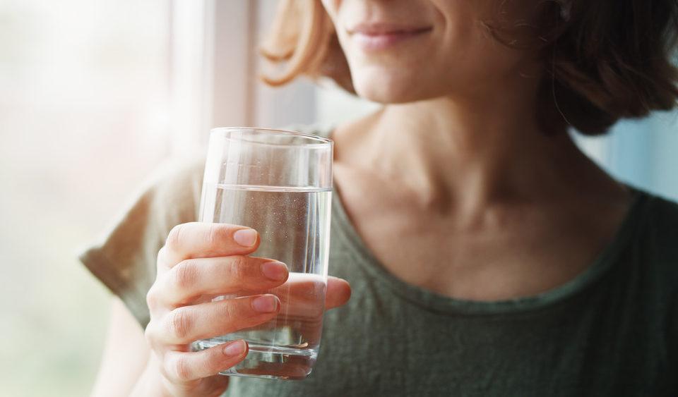 Femme tenant un verre d'eau